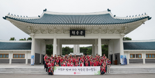 롯데건설 임직원 가족들이 현충문 앞에서 봉사활동 기념촬영을 하고 있다. <롯데건설 제공>
